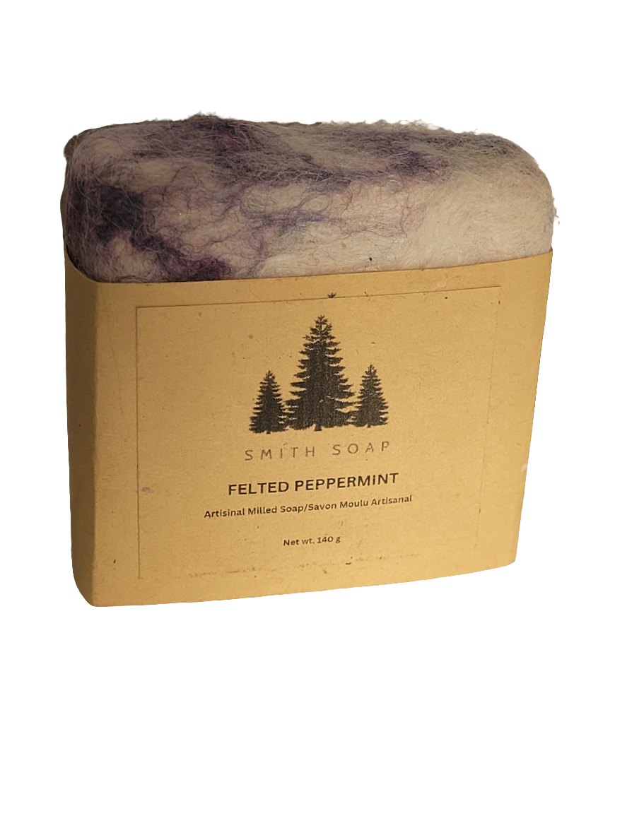 A bar of soap covered in purple and white alpaca felt. Wrapped in a craft label.